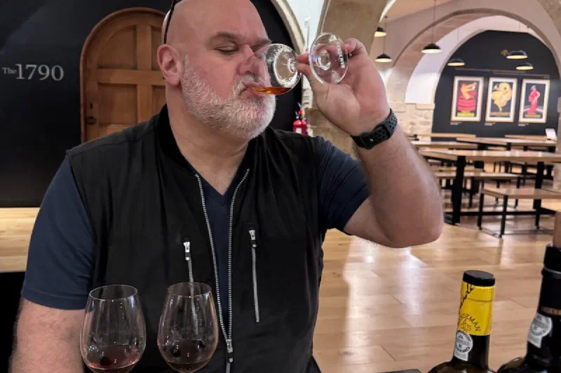 Matt nosing a glass of port at Sandeman, &ldquo;The 1790&rdquo; arch and stone vaults visible behind him